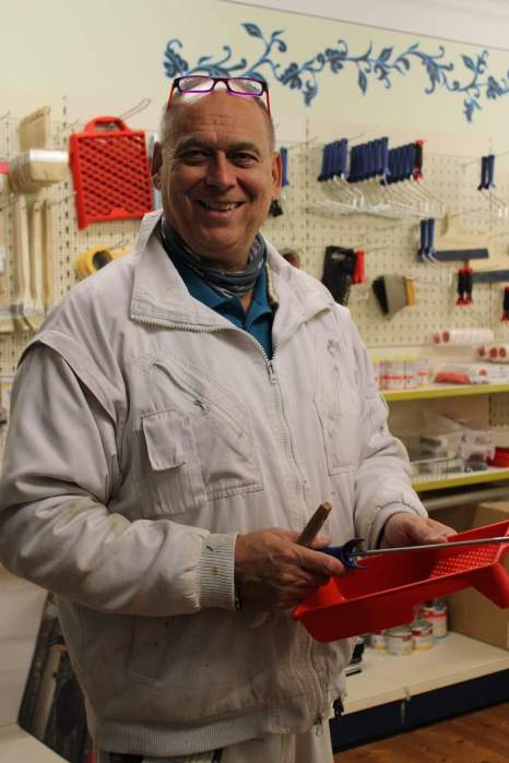 Interior of a paint and color retail shop in Austria, shelves full of paint cans, color swatch wall, clean modern look